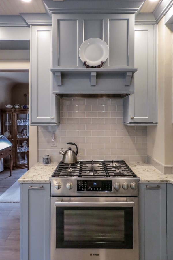 Light gray cabinets surrounding stainless steel slide-in range and subway tile backsplash, Golden Rule Remodeling & Design, Salem Oregon